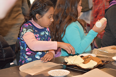 young girl decorating cookies