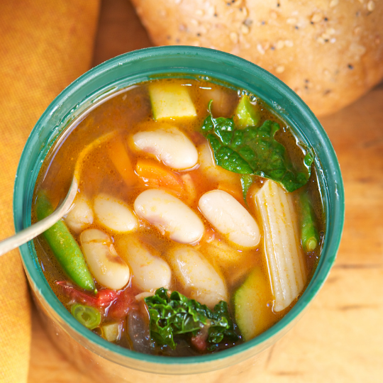 Hearty white bean and vegetable soup with kale, zucchini, beans and carrots. 