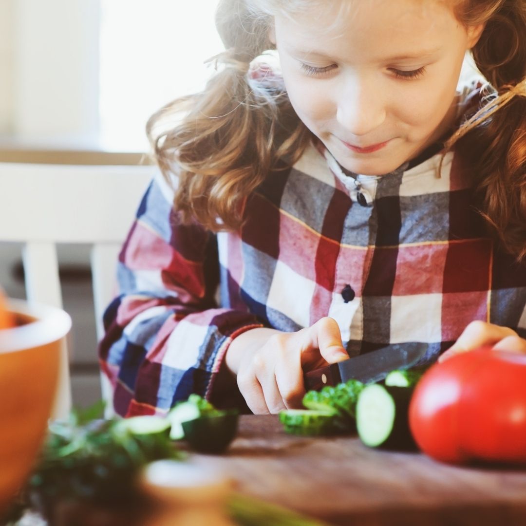 young girl cutting vegetables