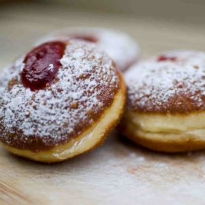 Homemade jelly filled doughnut sprinkled with icing sugar